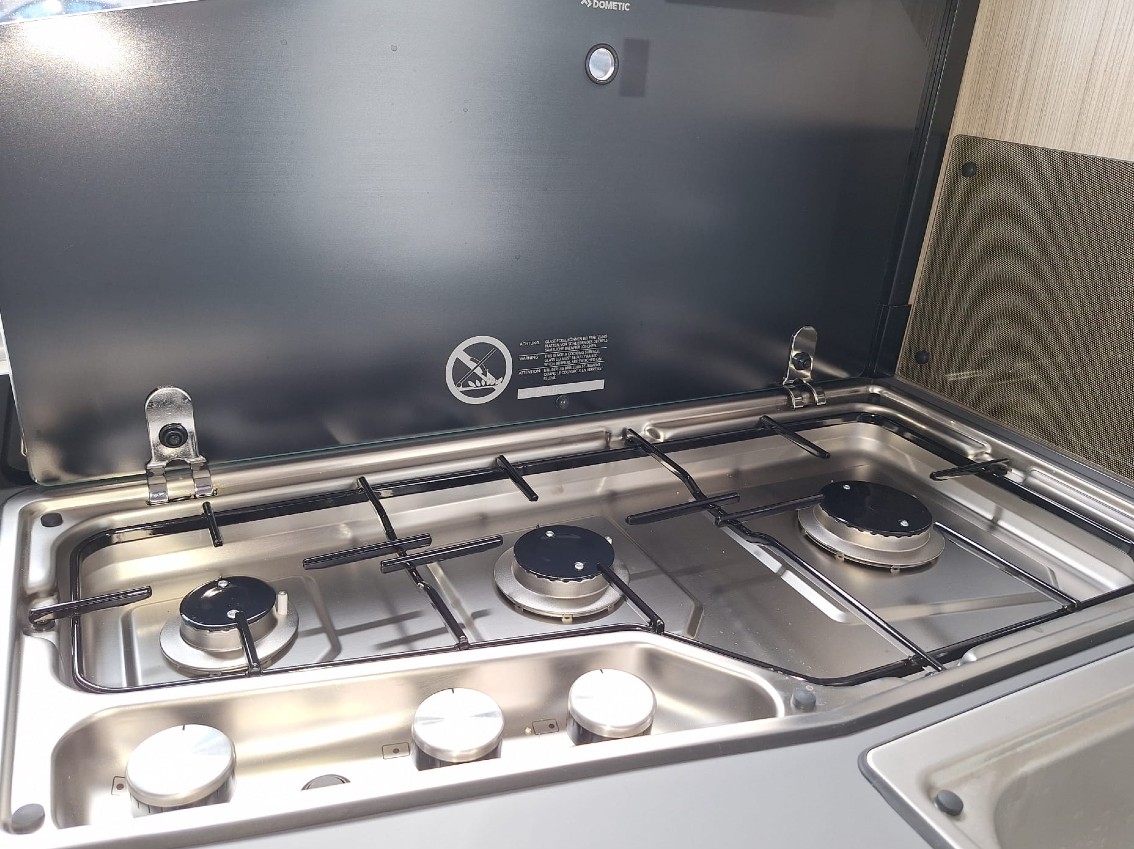Detail van het kookstel in de Sun Living S72DL camper, met drie gaspitten en een glazen afdekplaat, ingebouwd in een strak aanrechtblad