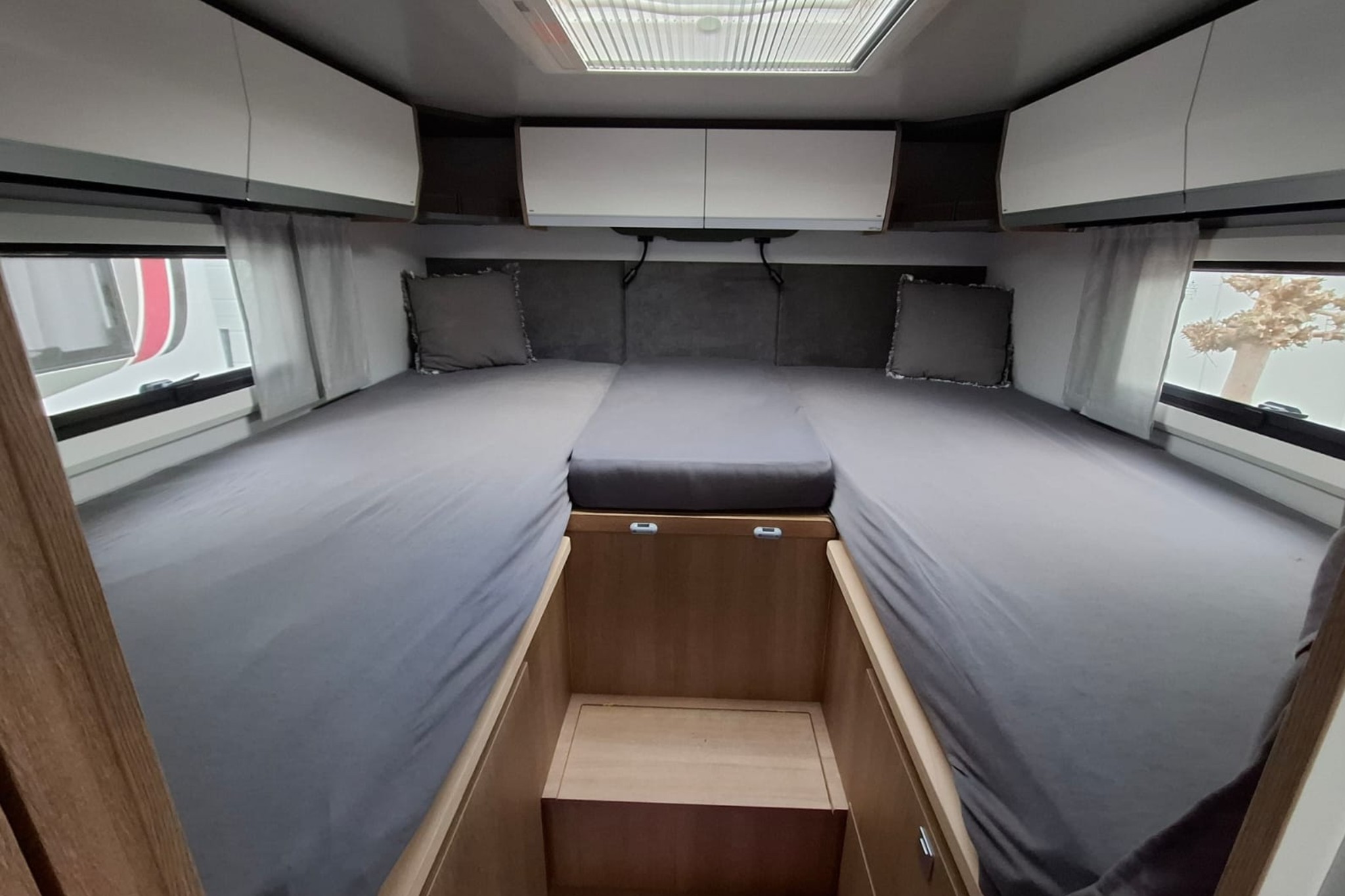 Lengtebed met zachte bekleding en leeslampjes in de Giottiline 69GC camper